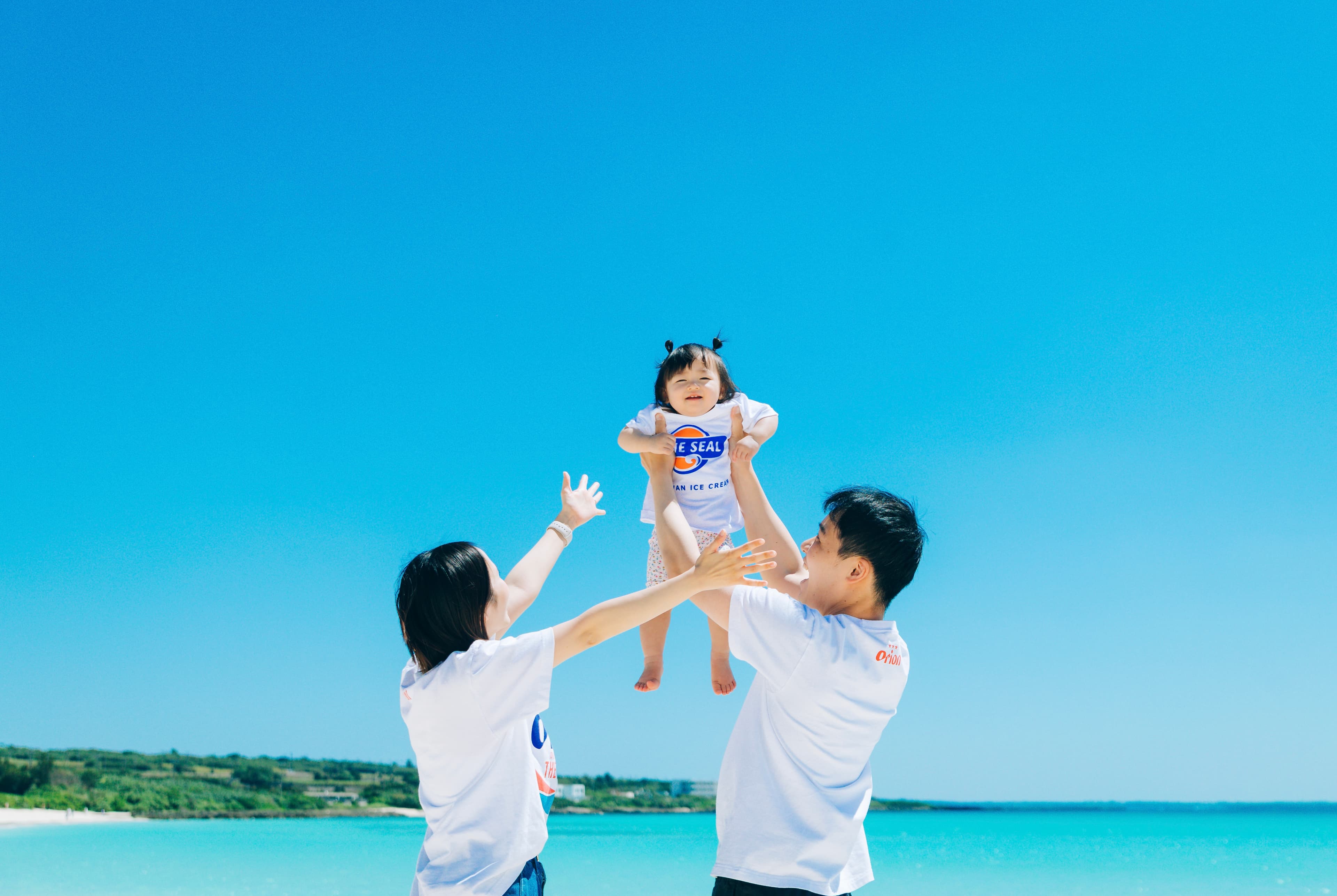 宮古島での家族写真撮影：ビーチで子供を高く抱き上げる親子
